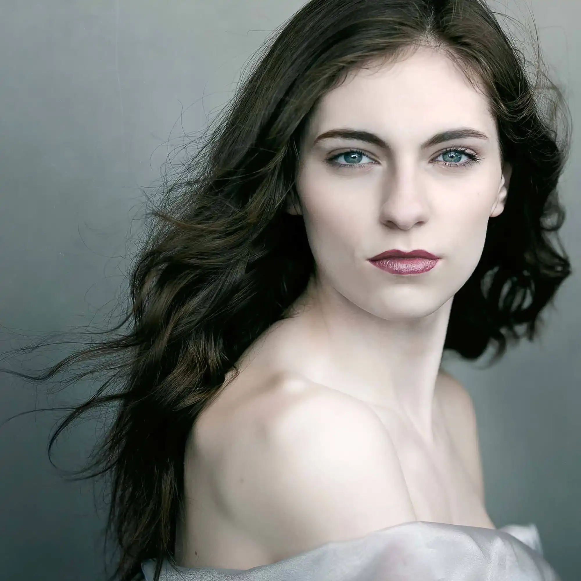 Ethereal Beauty Lauren Dod Captivating Model Portrait Dramatic close-up of model Lauren Dod with flowing brunette locks, showcasing her luminous blue eyes and sculpted cheekbones in cool, muted tones.