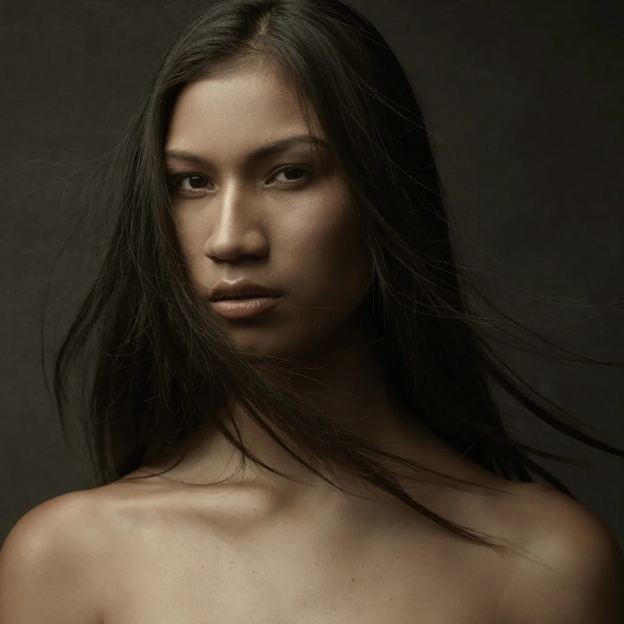 Model Headshot: Pushes Boundaries at Schacht’s First Gallery Show Striking ethnically ambiguous portrait with muted tones by Chicago Headshot Photographer, Michael Schacht, captures model's intense gaze, showcasing his artistic headshot style at his gallery debut.