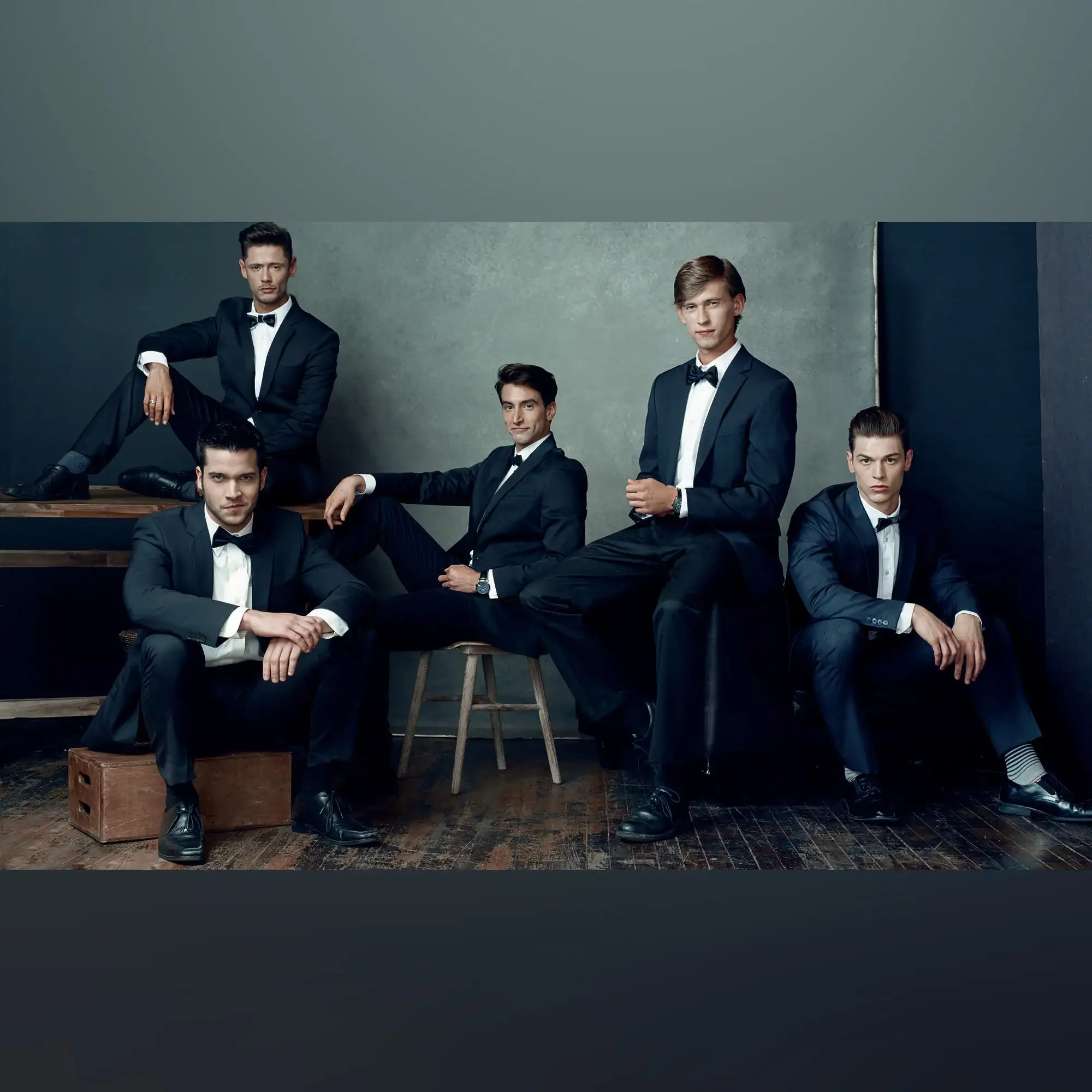 Timeless Elegance: Gentlemens Group Portrait in Classic Tuxedos Five dapper gentlemen in black tuxedos stand confidently together, exuding elegance and camaraderie in this sophisticated group portrait.